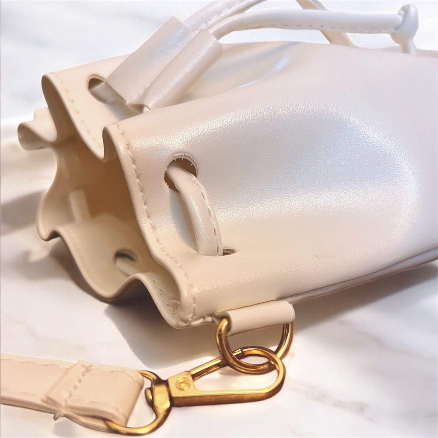 Close-up of a white shoulder with gold hardware