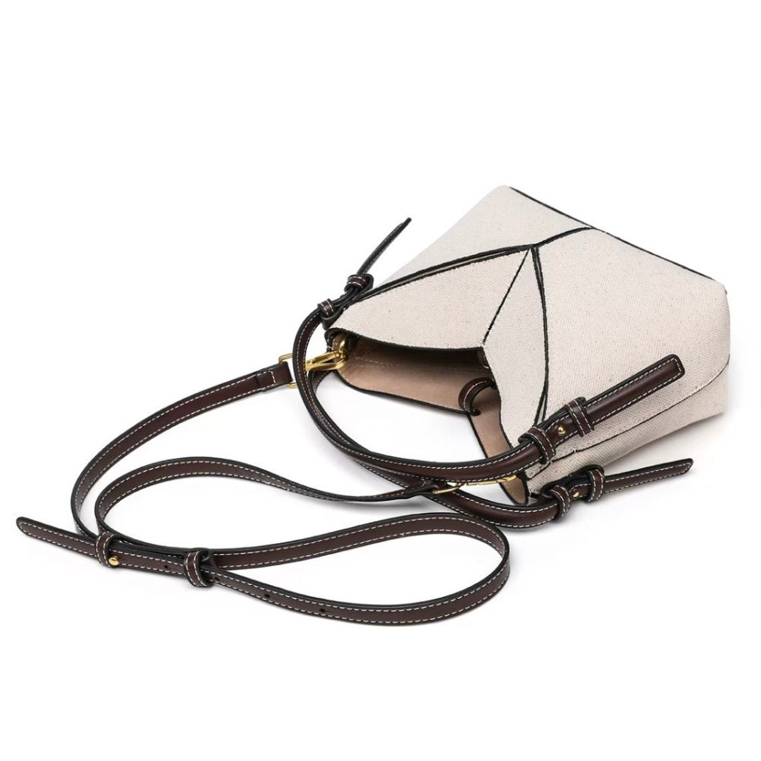 White handbag with brown leather strap on a white background