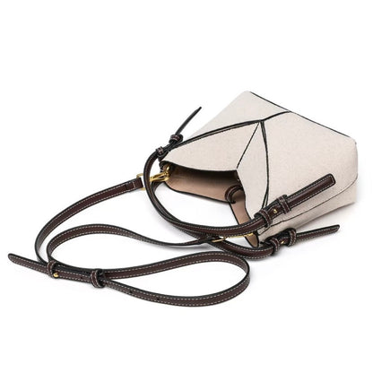 White handbag with brown leather strap on a white background